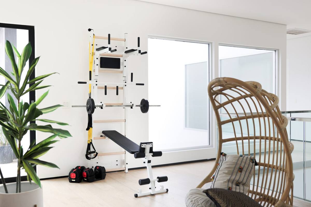 BenchK Series 7 complete home gym setup with wall bars, bench, and suspension system in a modern living space
